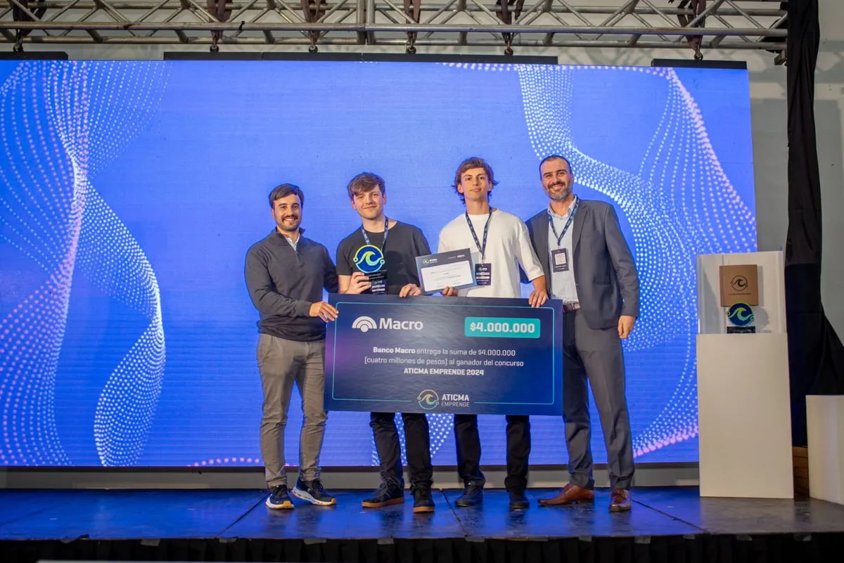 El equipo de Roomix, ganador de ATICMA Emprende 2024, recibe el cheque del premio en el escenario
